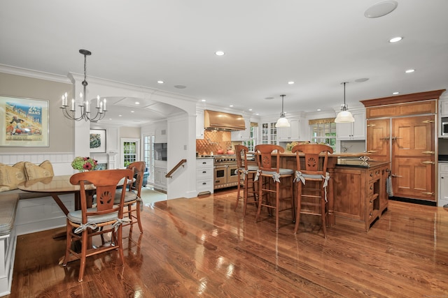 dining area with a chandelier, recessed lighting, dark wood-style flooring, and crown molding