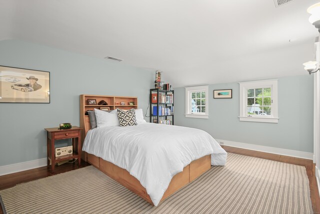 bedroom featuring baseboards, visible vents, and wood finished floors