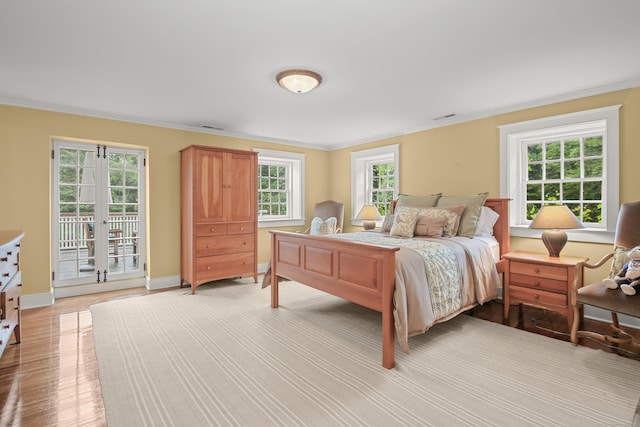 bedroom with french doors, crown molding, light wood-style flooring, access to outside, and baseboards