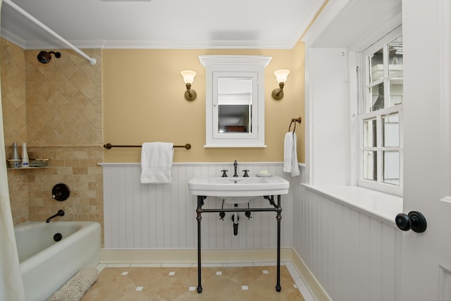 bathroom with tile patterned flooring, a wainscoted wall, a sink, bathing tub / shower combination, and crown molding