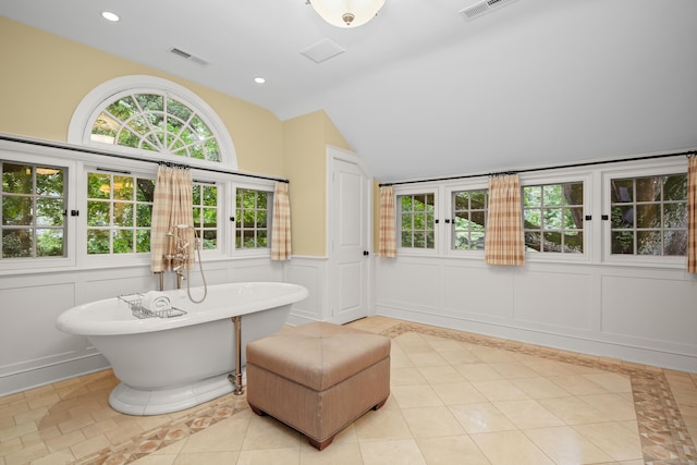 full bathroom with lofted ceiling, recessed lighting, a decorative wall, visible vents, and a soaking tub