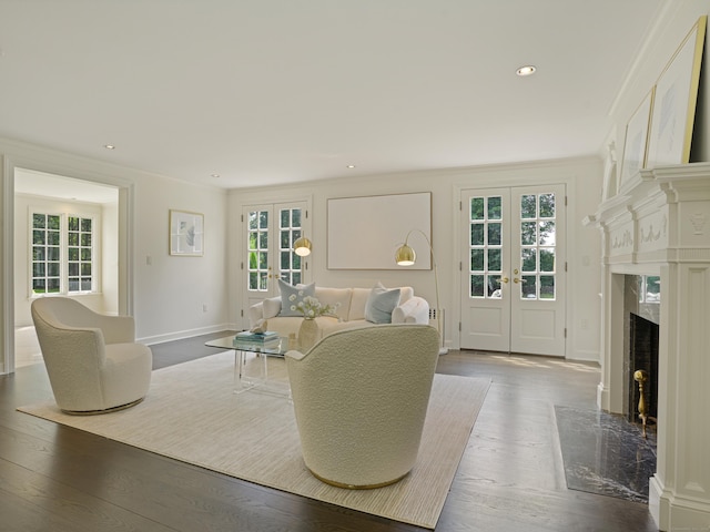 living room with hardwood / wood-style flooring, ornamental molding, a fireplace, and french doors