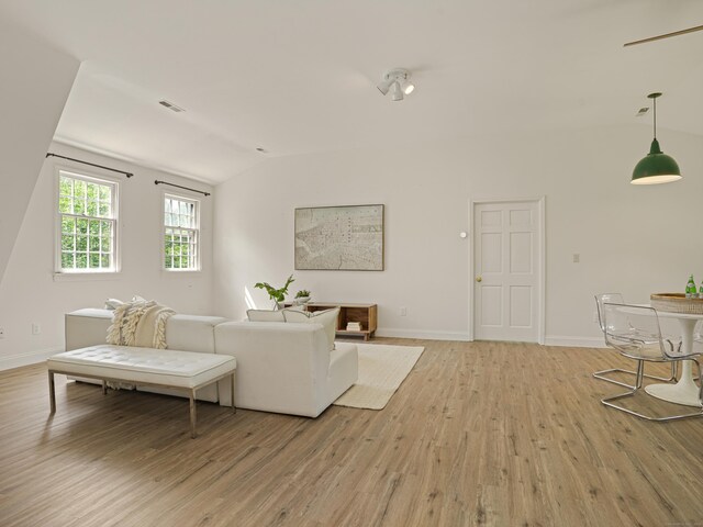 living room featuring vaulted ceiling and light wood-type flooring