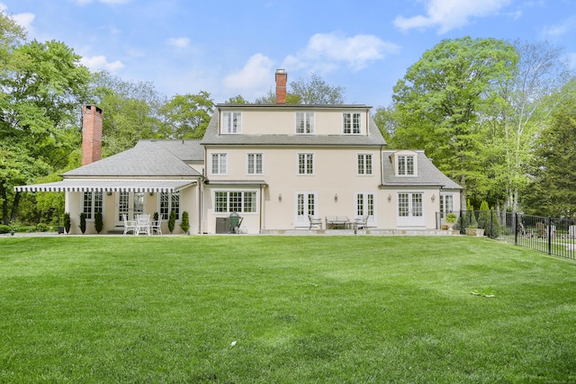 rear view of property with a yard and a patio