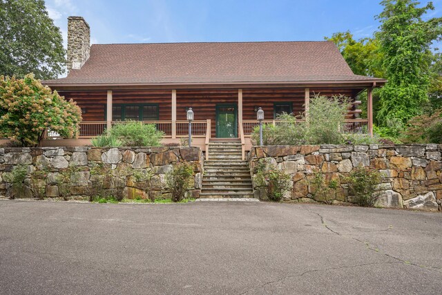 log cabin featuring covered porch