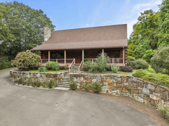 log home featuring covered porch