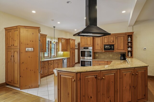 kitchen featuring island exhaust hood, hanging light fixtures, kitchen peninsula, stainless steel appliances, and light stone counters