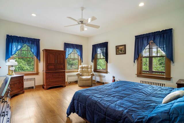 bedroom with radiator, ceiling fan, and light hardwood / wood-style floors