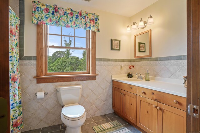 bathroom featuring tile walls, toilet, vanity, and tile patterned floors