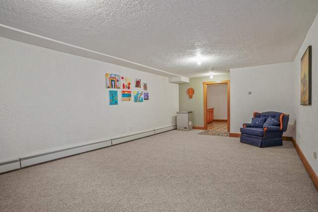 unfurnished room with a textured ceiling, light colored carpet, and baseboard heating