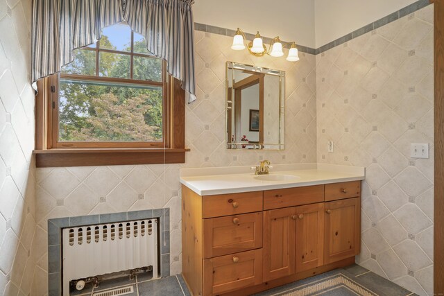 bathroom with radiator heating unit, vanity, and tile walls