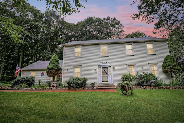 colonial home featuring a front lawn