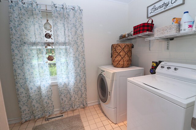 clothes washing area with washing machine and dryer, light tile patterned flooring, and ornamental molding