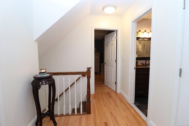 hall featuring light hardwood / wood-style flooring and vaulted ceiling