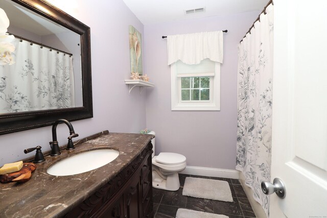 bathroom with tile patterned flooring, vanity, and toilet