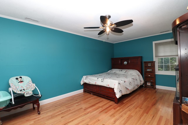 bedroom with light wood-type flooring, ornamental molding, and ceiling fan