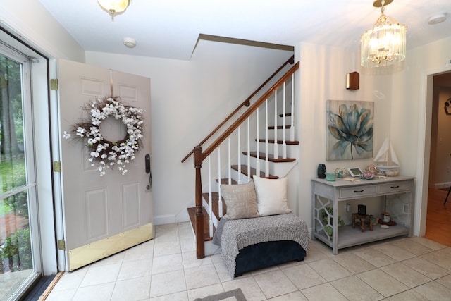 tiled entrance foyer featuring an inviting chandelier and a healthy amount of sunlight