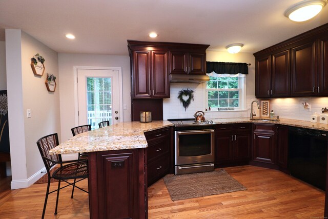 kitchen with black dishwasher, stainless steel stove, light wood-type flooring, and tasteful backsplash