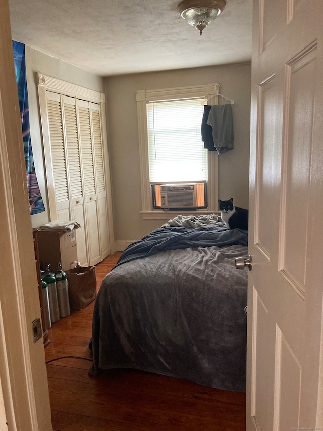 bedroom featuring cooling unit, a closet, and wood-type flooring