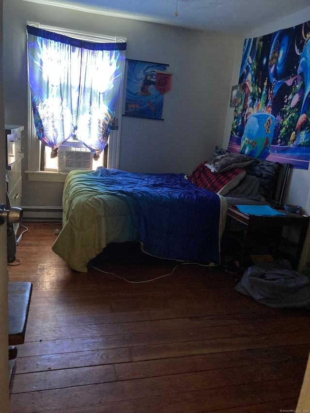 bedroom featuring a baseboard heating unit and wood-type flooring