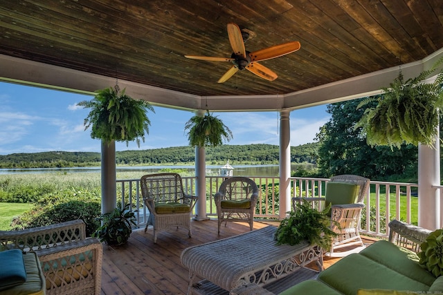 wooden terrace featuring a water view and ceiling fan