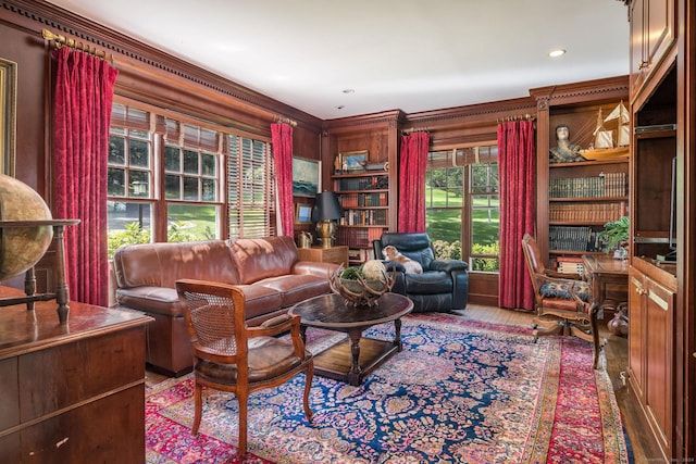 living room featuring ornamental molding, wood-type flooring, and built in shelves