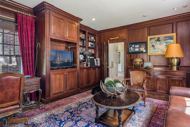 living room with ornamental molding, built in features, and wood walls