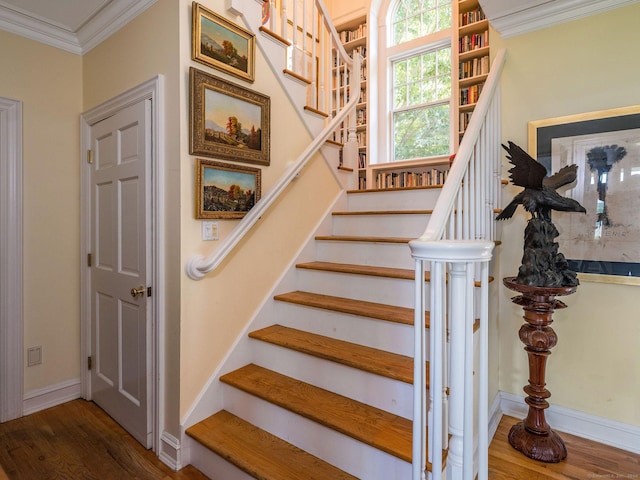 stairway with ornamental molding and hardwood / wood-style floors