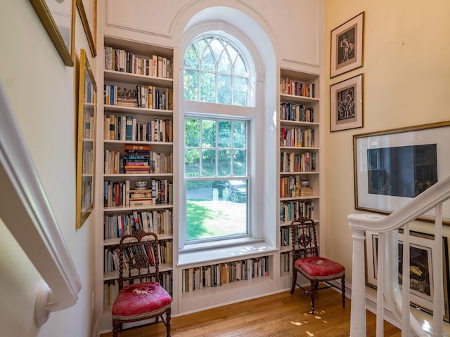 sitting room with built in shelves, light wood-type flooring, and a healthy amount of sunlight