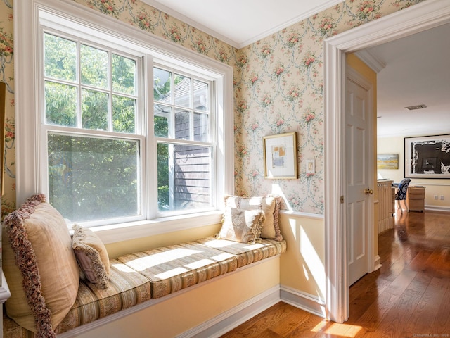 sitting room with wood-type flooring and ornamental molding