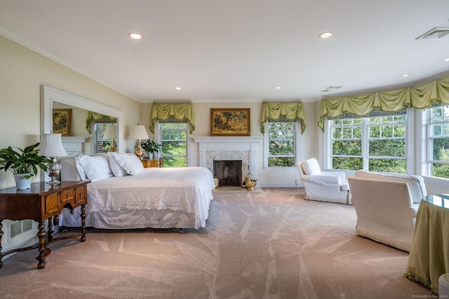 bedroom featuring light carpet, a fireplace, and ornamental molding