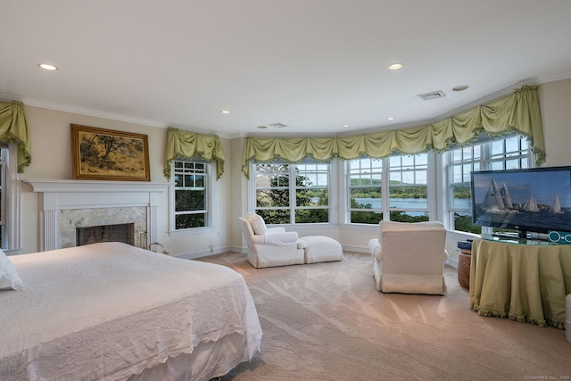 bedroom with ornamental molding, light carpet, and a premium fireplace