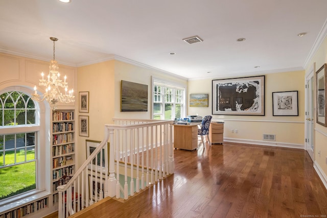 corridor with an inviting chandelier, ornamental molding, and dark hardwood / wood-style flooring