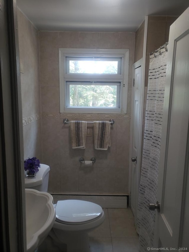 bathroom with tile patterned flooring, tile walls, toilet, and sink