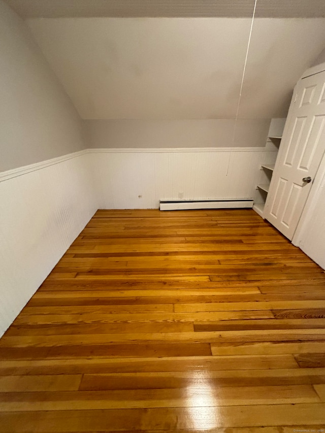 additional living space featuring light hardwood / wood-style flooring and baseboard heating