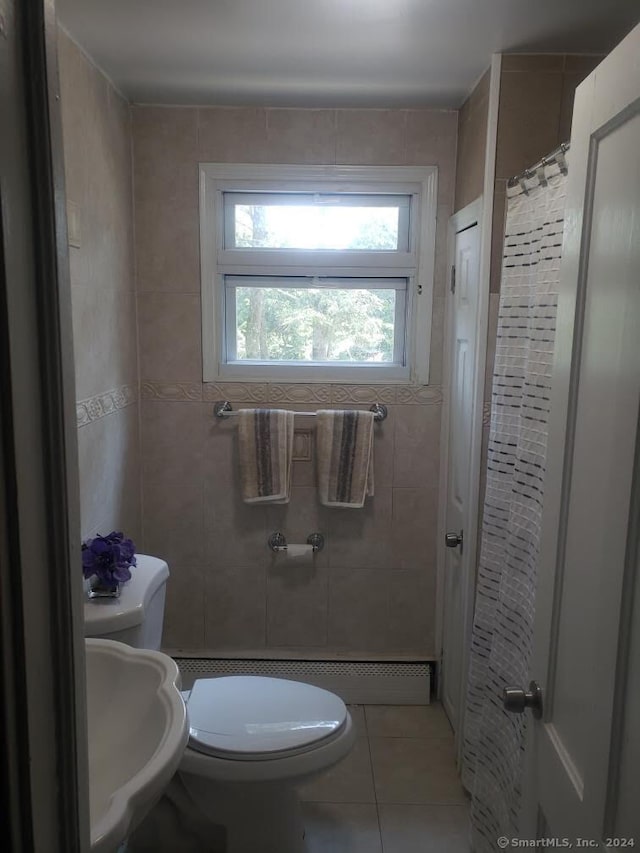 bathroom featuring sink, toilet, tile patterned floors, and tile walls