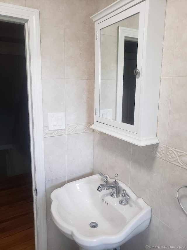 bathroom with sink and tile walls