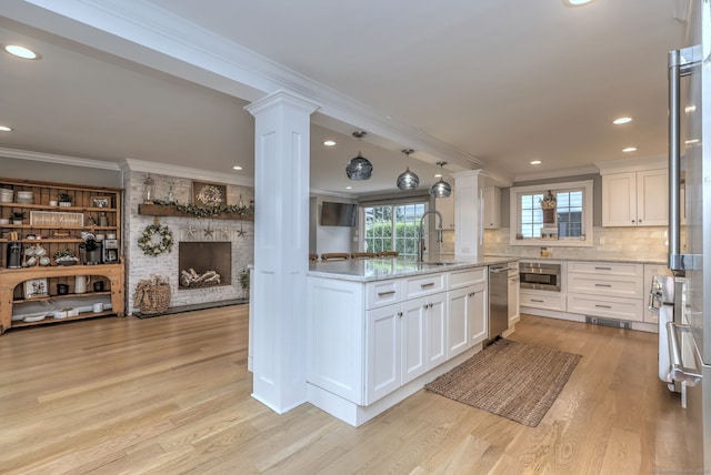 kitchen with light hardwood / wood-style flooring, a fireplace, light stone counters, and white cabinetry