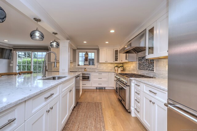 kitchen featuring white cabinetry, pendant lighting, light hardwood / wood-style floors, stainless steel appliances, and sink