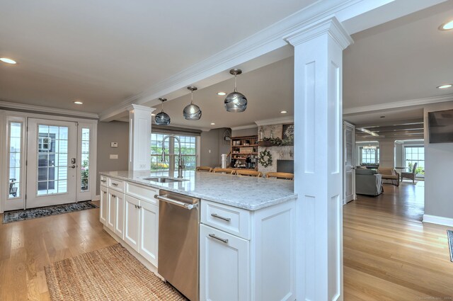 kitchen with white cabinets, a healthy amount of sunlight, stainless steel dishwasher, and light hardwood / wood-style floors