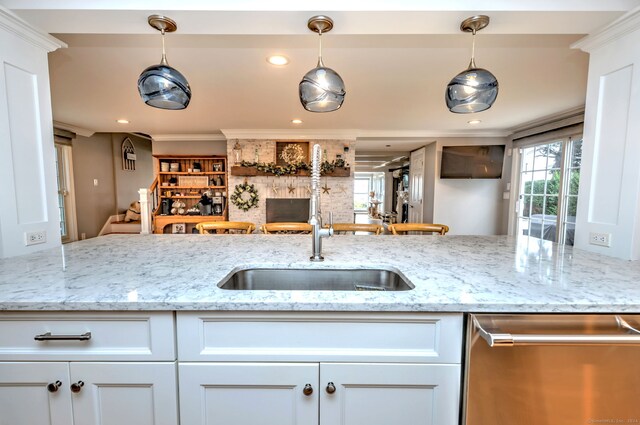 kitchen featuring crown molding, white cabinets, dishwasher, light stone countertops, and decorative light fixtures