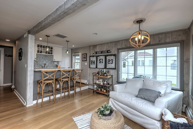 living room with light wood-type flooring and an inviting chandelier