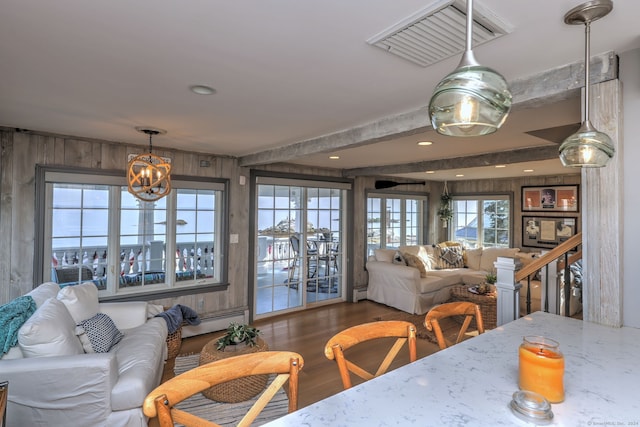 dining room featuring beamed ceiling, wooden walls, wood-type flooring, and baseboard heating