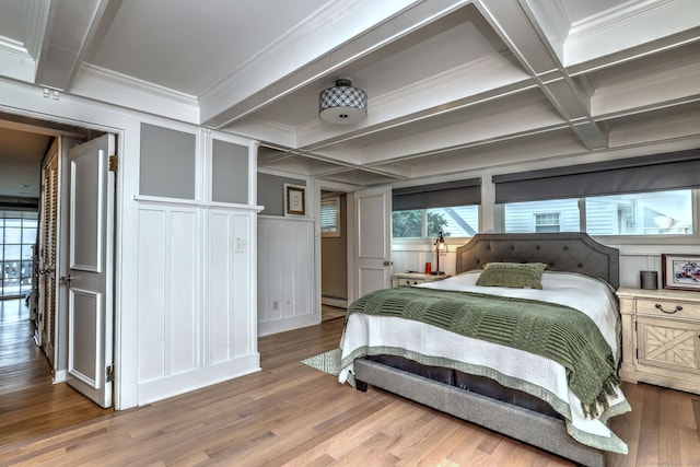 bedroom with beam ceiling, hardwood / wood-style flooring, coffered ceiling, ornamental molding, and a baseboard heating unit