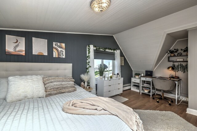 bedroom with baseboard heating, a chandelier, lofted ceiling, and hardwood / wood-style flooring