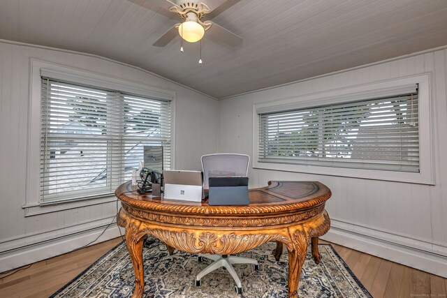 home office featuring ceiling fan, a baseboard radiator, hardwood / wood-style floors, and vaulted ceiling