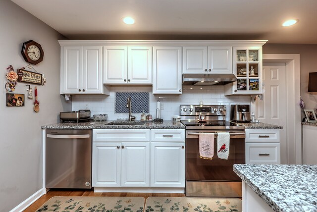 kitchen with tasteful backsplash, light wood-type flooring, dishwasher, white cabinetry, and range with electric stovetop