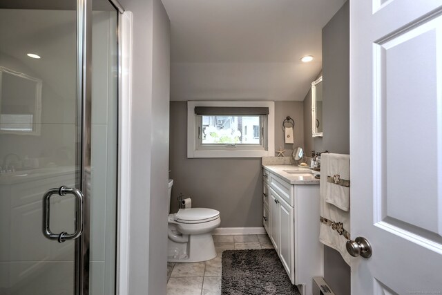 bathroom with an enclosed shower, vanity, toilet, and tile patterned flooring