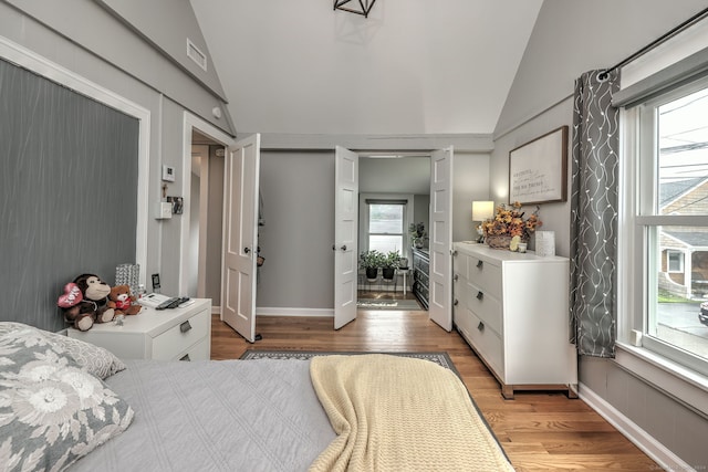 bedroom with vaulted ceiling and light hardwood / wood-style floors