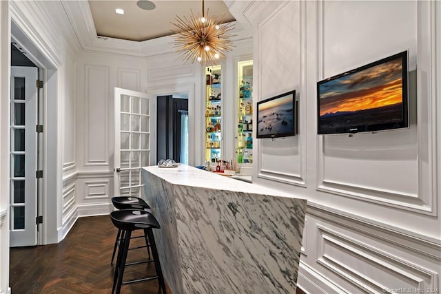 bar featuring a chandelier, white cabinetry, and dark parquet flooring